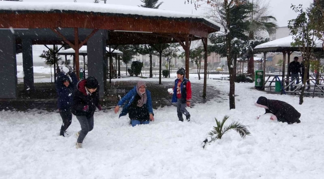 Lapa lapa yağan kar altında çocukların kartopu keyfi