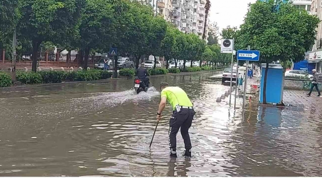 Polisten örnek davranış: Su dolu caddede tıkanan rögarı açtı