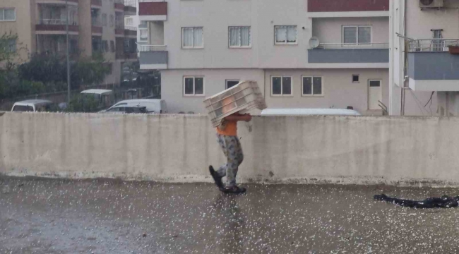 Dolu yağışında küçük çocuk plastik kasa altında eğlendi, sürücüler ağaç altına sığındı